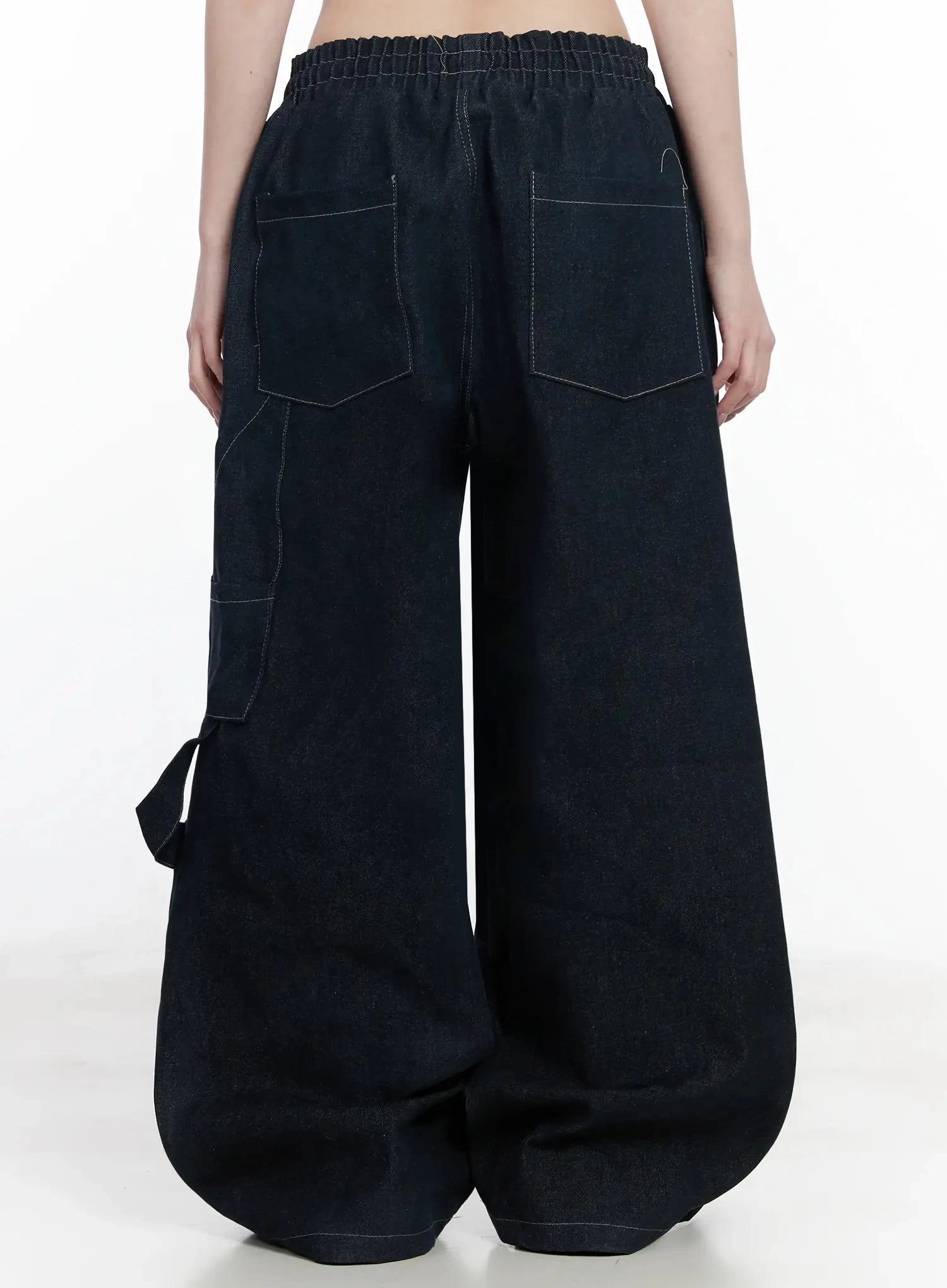 Ashlyn Carpenter Wide-Leg Jeans IJ528 in dark blue, back close-up waist-to-hem shot, elastic waistband, dual rear patch pockets and side cargo pocket with white contrast stitching detail.