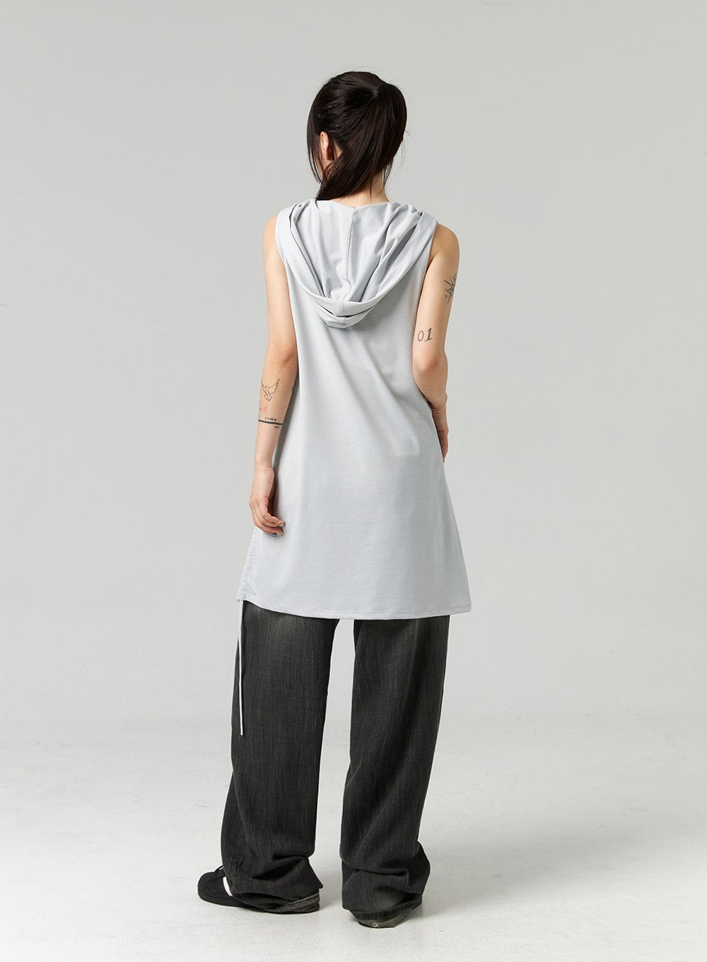 Baggy Jeans CL321 in washed dark grey, full-body back view on model, wide-leg washed denim with gradient fade, voluminous silhouette, styled with grey hooded sleeveless top.