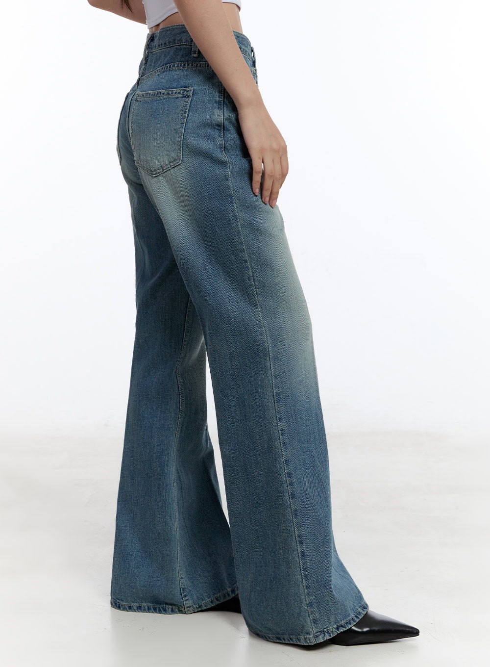 Aliya Washed Bootcut Jeans IU503 in dark blue, rear three-quarter side shot, back pocket detail and bootcut flare visible, washed cotton denim with subtle fading at hip and thigh.