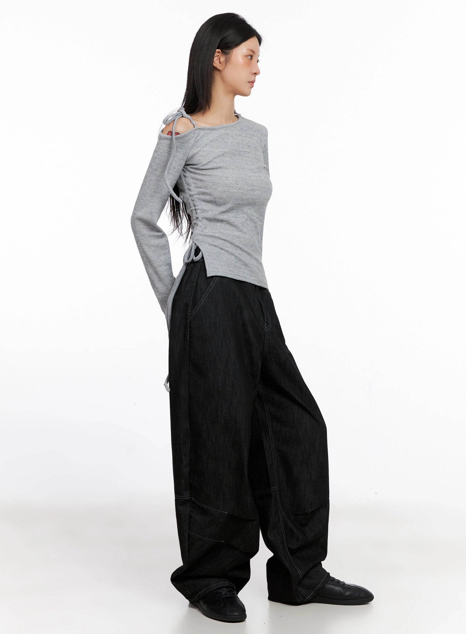 Leyla Pin-Tuck Wide-Leg Jeans IS515 in black, side view on model in grey cutout long-sleeve top, balloon wide-leg silhouette and pintuck seam panel shown in profile.