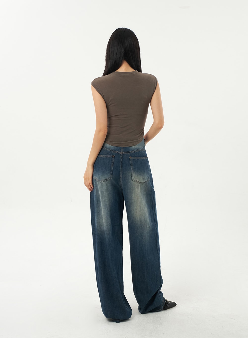 Baggy Low Rise Jeans CA326 in dark blue, back full-length view on model, rear patch pockets with faded wash, wide-leg denim pooling at floor, paired with brown crop top.