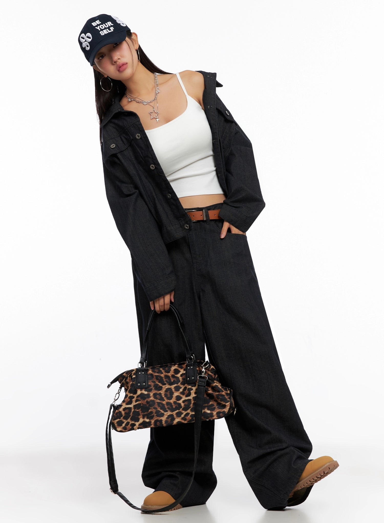 Heidi Wide-Leg Jeans IG527 in dark blue, full-body editorial on model with navy cap, white crop top, open dark denim jacket, brown belt, and leopard print bag — street style look.