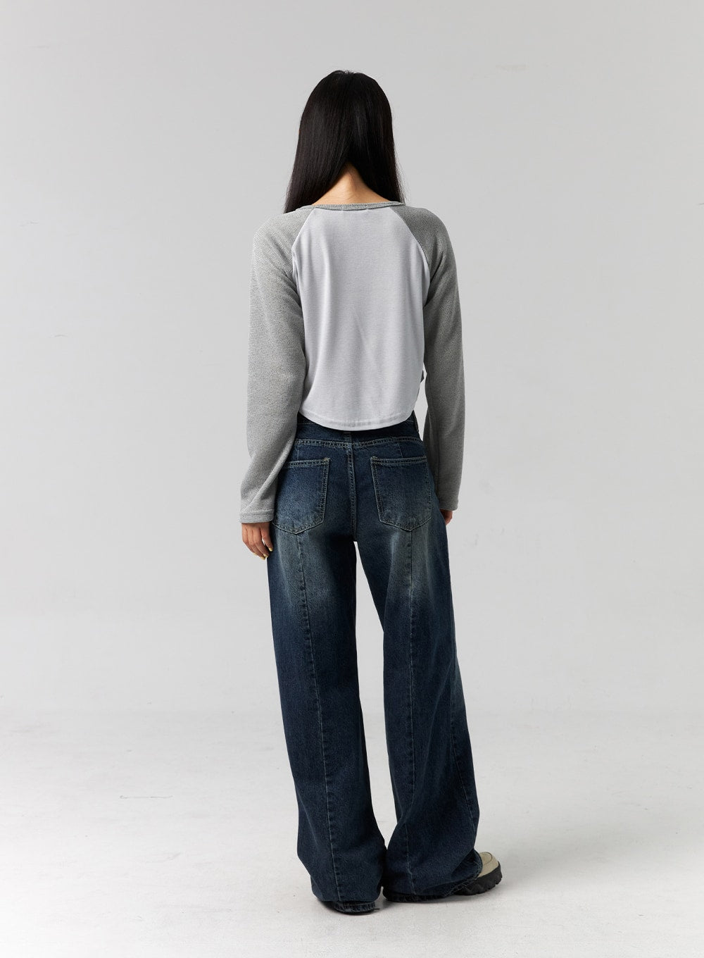 Low Rise Washed Wide Jeans CG315 in dark blue, full-body back view on model, back patch pockets with faded washed detailing, wide floor-length leg, paired with grey raglan crop top.