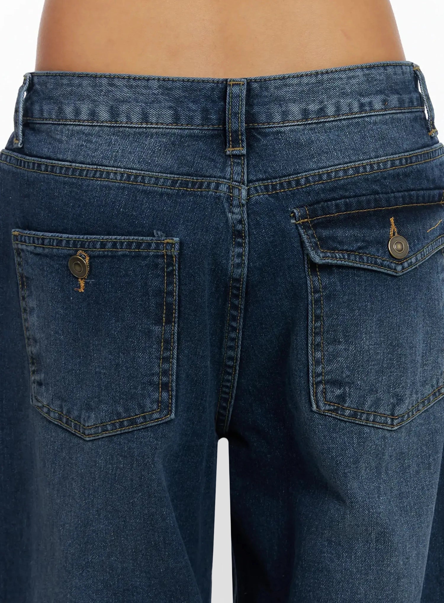 Anahi Baggy Jeans IN528 in blue, close-up back pocket detail shot, featuring washed denim texture, contrast stitching, and brass snap button hardware.