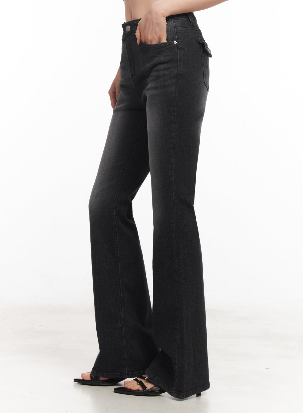 Lior Slim-Fit Bootcut Jeans IY516 in black, side full-length shot on model, washed slim-fit bootcut denim highlighting flare silhouette, back flap pocket detail visible, black strappy sandals.