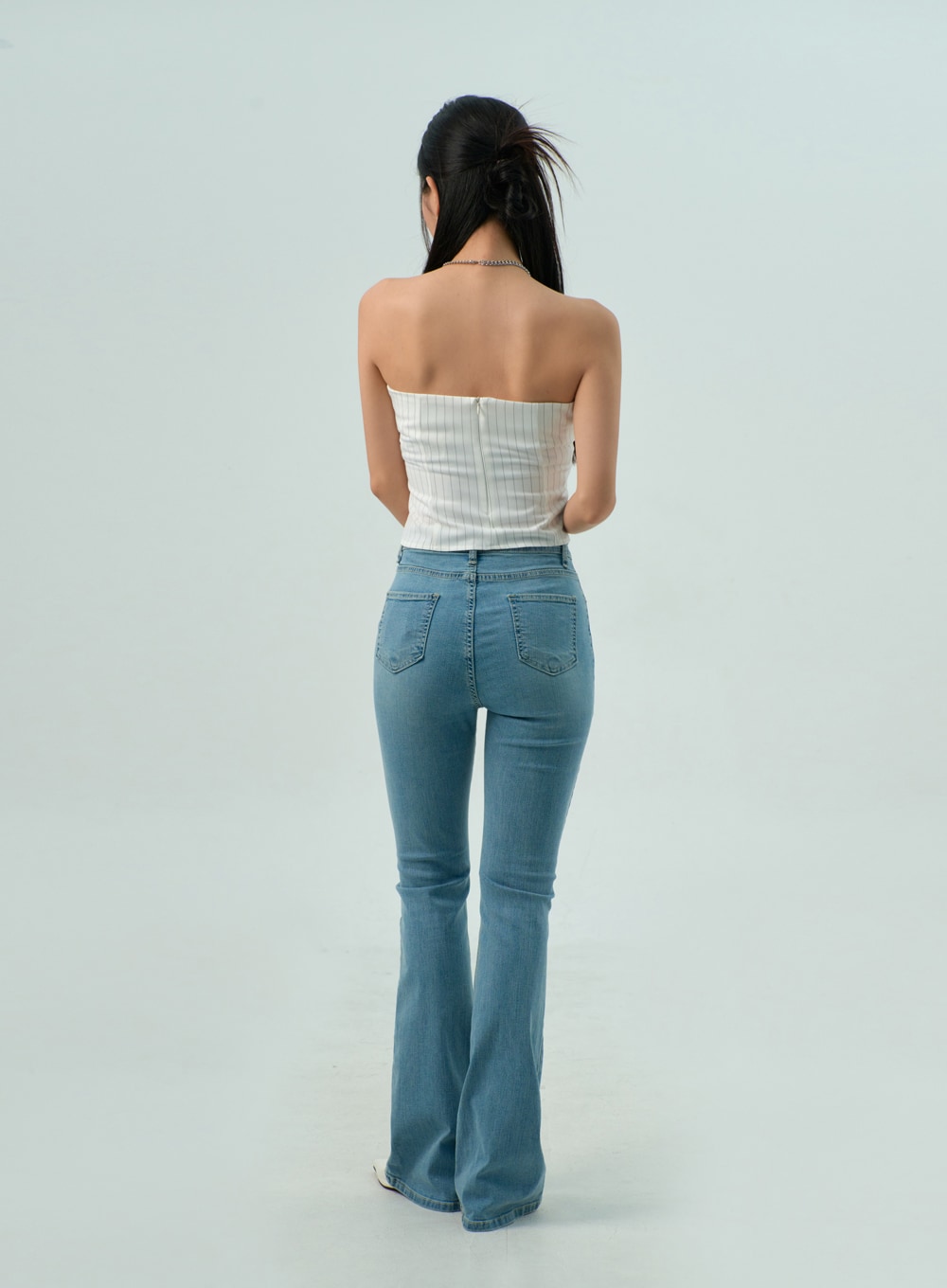 Light Wash Bootcut Jeans CY330 in light blue, full back view on model, dual patch back pockets, slim fit through seat hugging the silhouette, flared bootcut hem, washed cotton-spandex denim.
