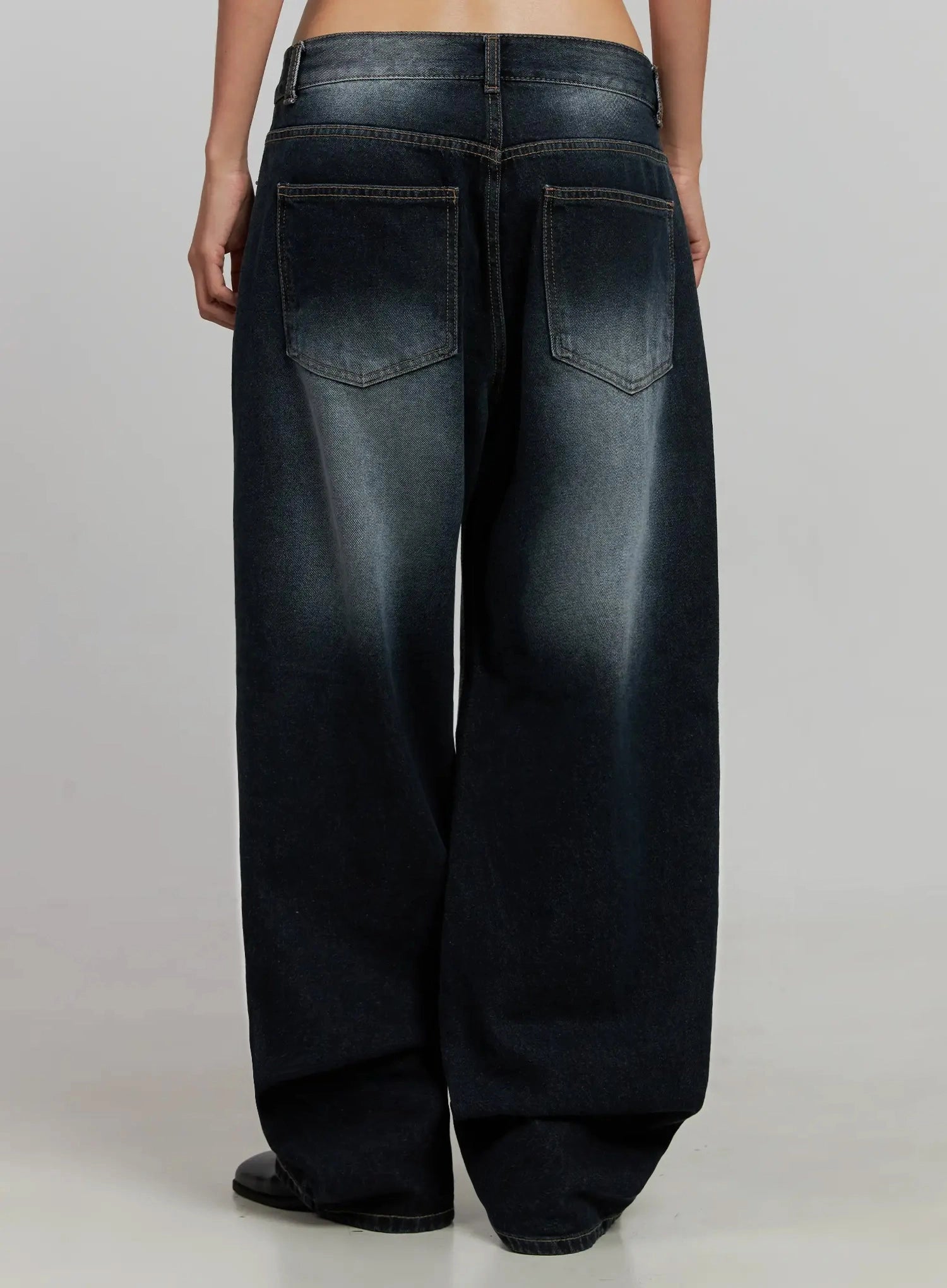 Chaya Washed Wide Jeans IJ505 in dark blue, back crop view on model without top, showing dual patch back pockets, washed fading and contrast brown stitching detail on cotton denim.