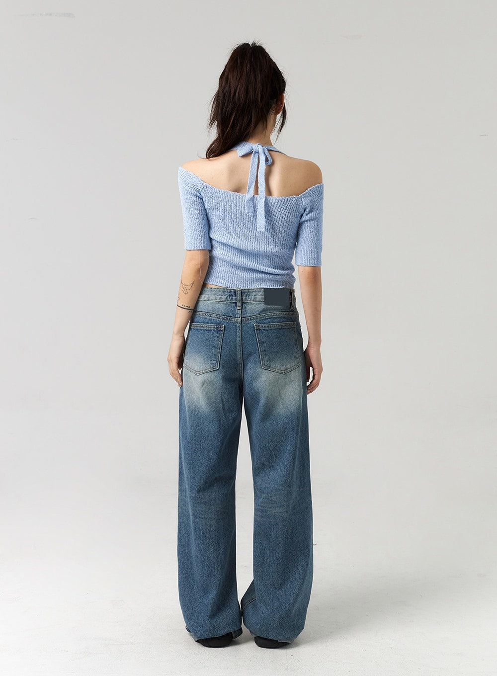 Mid-Wash Baggy Jeans CL312 in mid-wash blue, full back view on model, rear five-pocket detail with patch label, wide baggy leg and faded wash visible from behind.