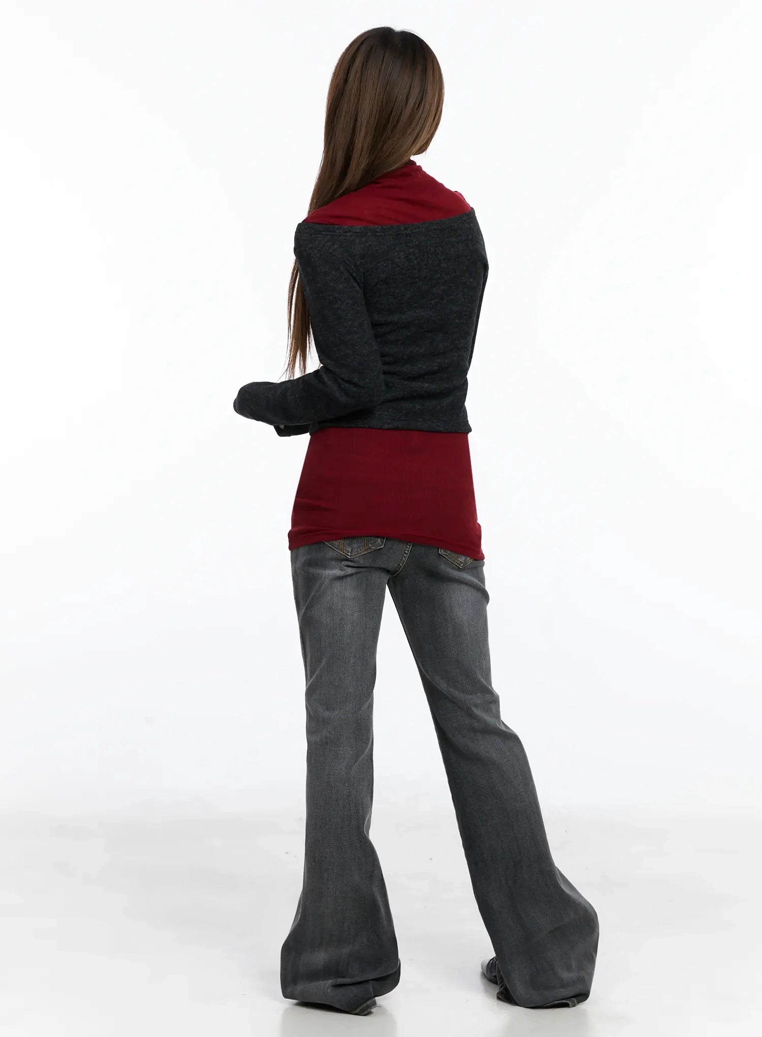 Phoe Flared Jeans ID503 in washed grey, full back view on model, back pocket stitching visible, flared hem spreading at floor, paired with layered burgundy turtleneck and grey cardigan.