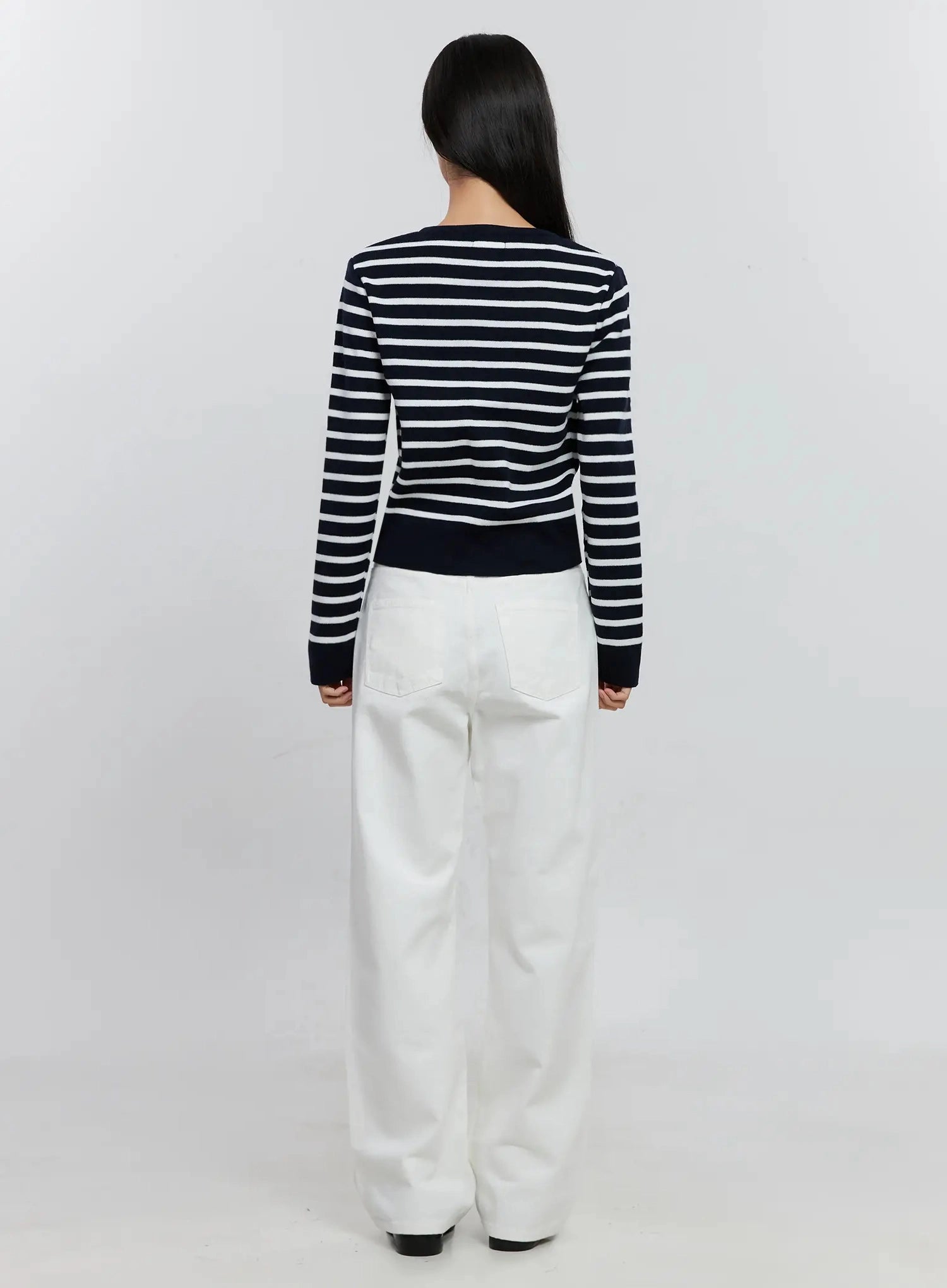 Taytum Straight-Leg Jeans IS515 in white, back full-length view on model, straight-leg cotton denim with patch back pockets, styled with navy striped cardigan and black loafers.