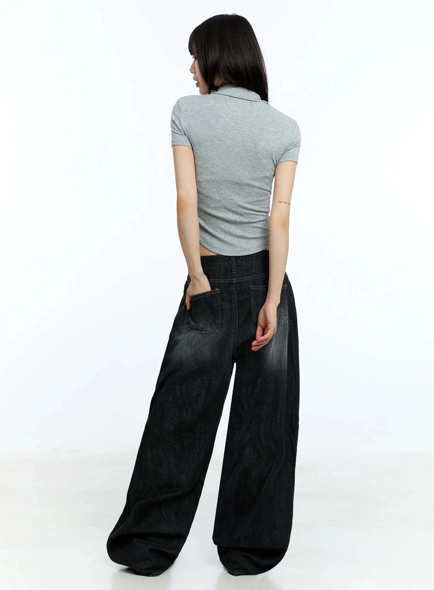 Wendy Washed Wide-Leg Jeans IU524 in black, full back view on model, back patch pockets with washed detailing, wide-leg volume from hip to floor, paired with grey polo crop top.