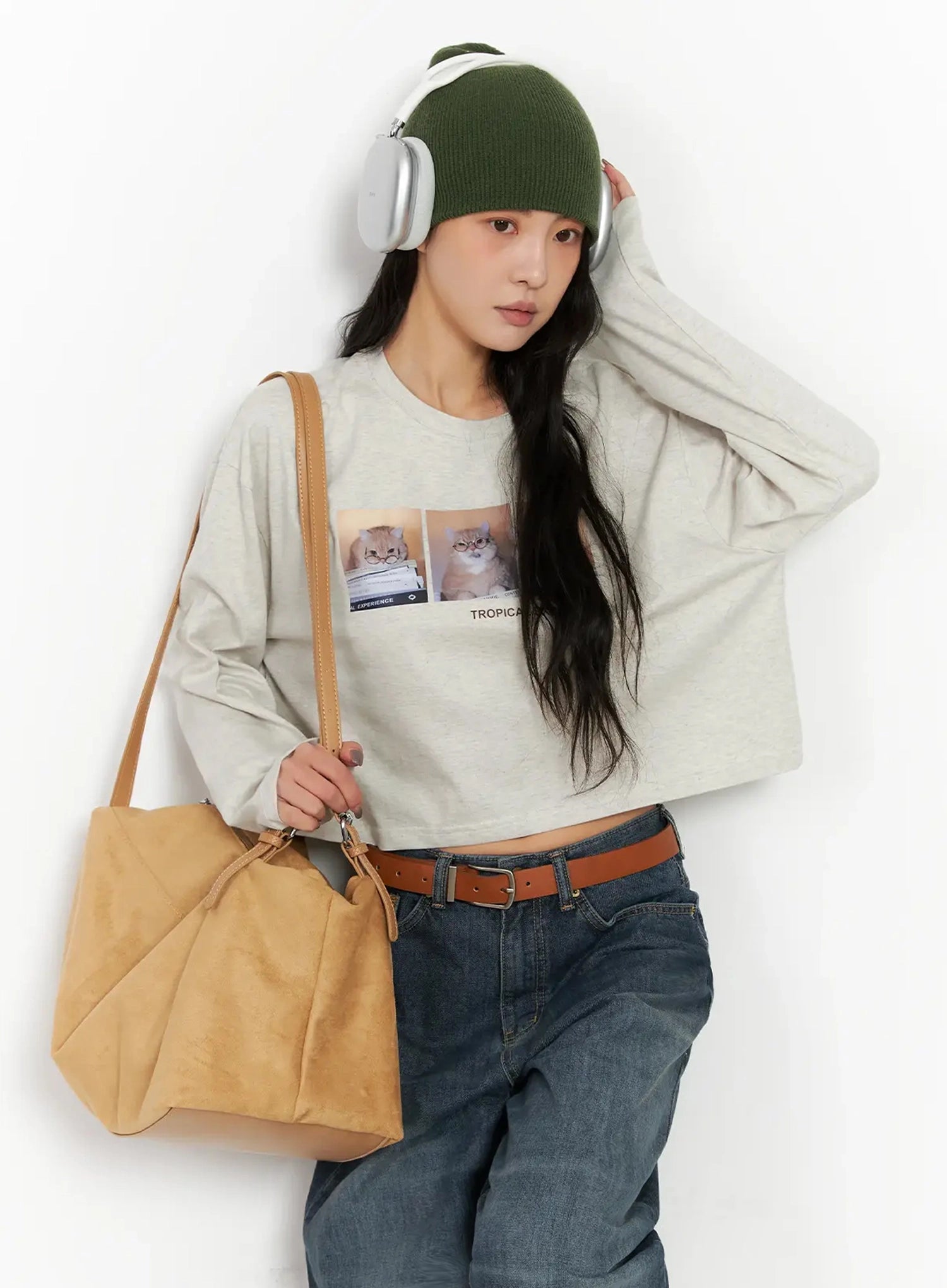 Regina Contrast Stitch Baggy Jeans IN528 in dark blue wash, front upper-body lifestyle shot on model, wide-leg denim with brown belt, styled with graphic crop tee, green beanie, headphones, and tan bag.