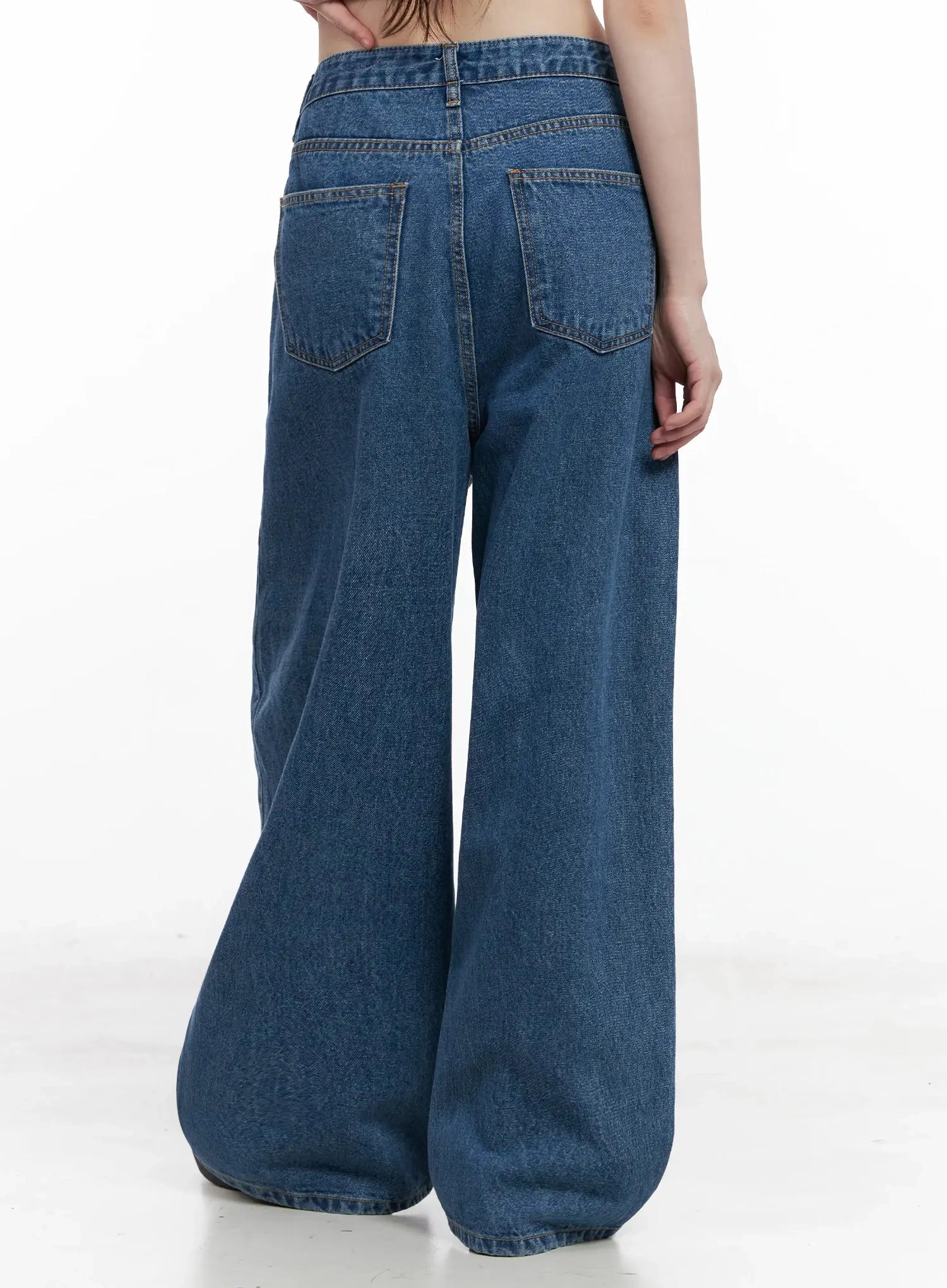 Pharita Loose-Fit Jeans IL528 in mid blue, back close-up on model, two back patch pockets with contrast topstitching, wide-leg hem and back waistband detail clearly shown.