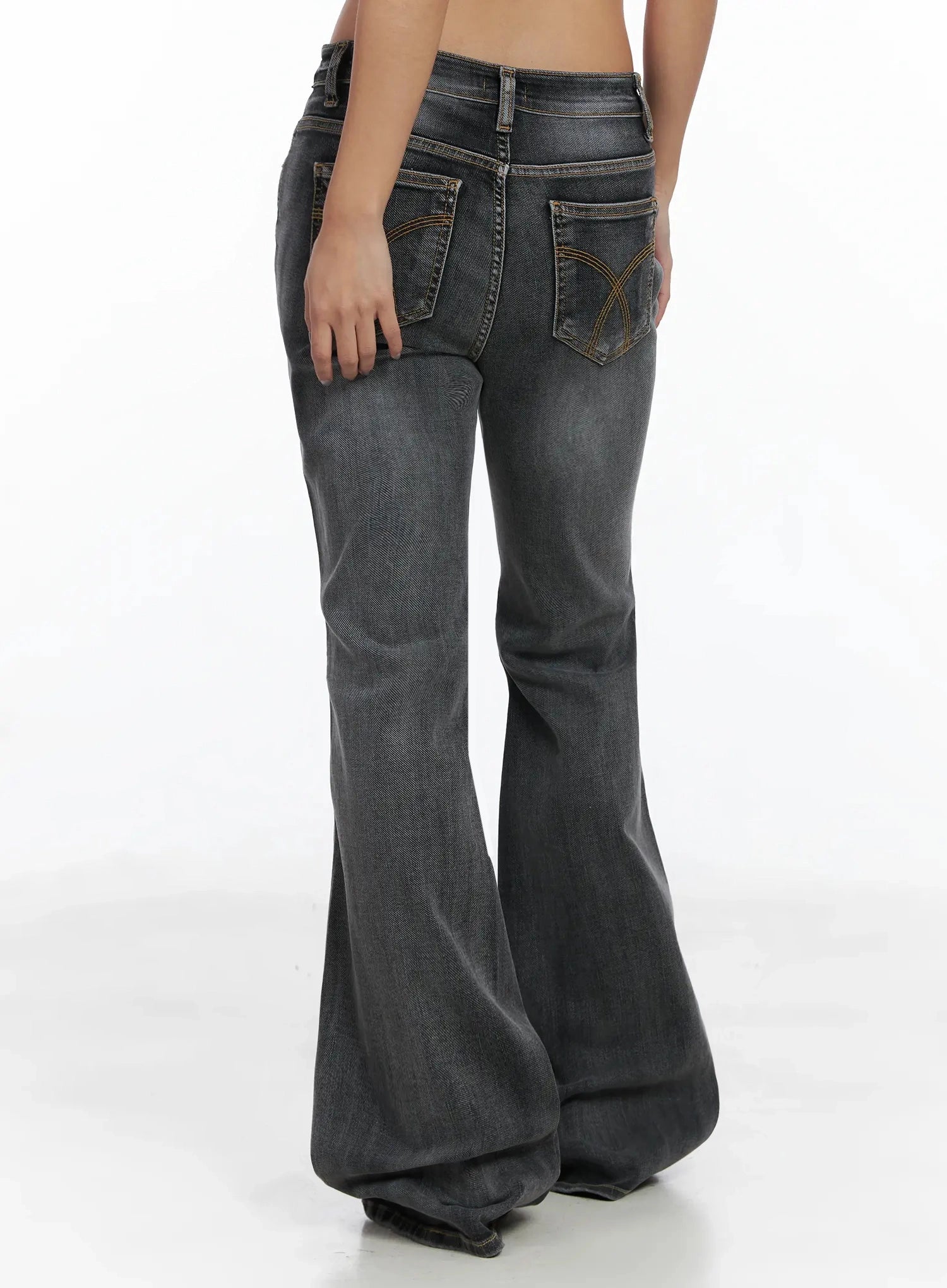 Phoe Flared Jeans ID503 in washed grey, back close-up from waist to mid-calf, highlighting decorative arc topstitching on back pockets and wide bell-bottom flare silhouette.