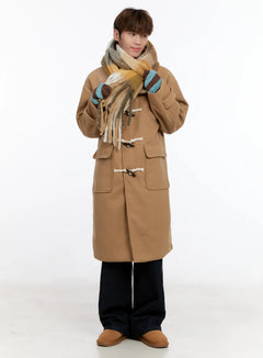 LEWKIN Men's Wool Blended Long Toggle Coat IN512 in beige, full-length front on model styled with plaid scarf and stripe mittens, midi-length wool blend with horn toggle closures, over wide-leg black trousers.
