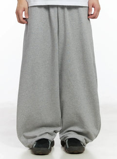 LEWKIN Men's Drawstring Hem Sweatpants IF517 in gray, front crop view on model, wide-leg fleece sweatpants with gathered drawstring hem, paired with white tee and dark sandals.