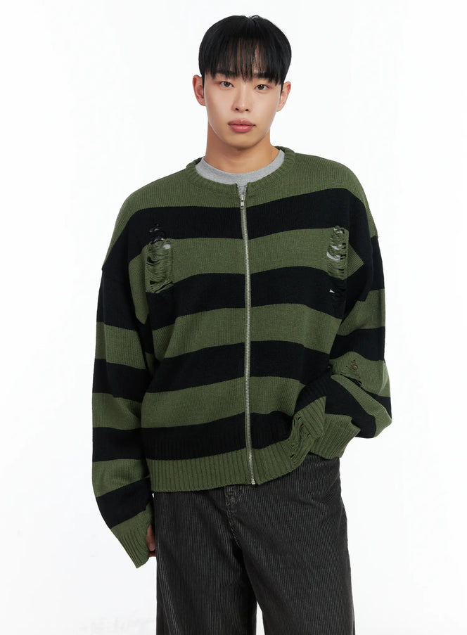 LEWKIN Men's Stripe Distressed Knit Cardigan IN518 in green, front half-body shot on model, oversized zip-up with bold black stripes, distressed holes, layered over grey tee with dark corduroy trousers.