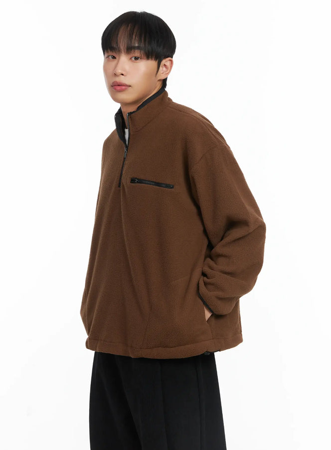 Warm Fleece Quarterzip ID515 in brown, three-quarter side view on model, oversize sherpa fleece with black quarter-zip neck, contrast chest zip pocket, paired with black trousers.