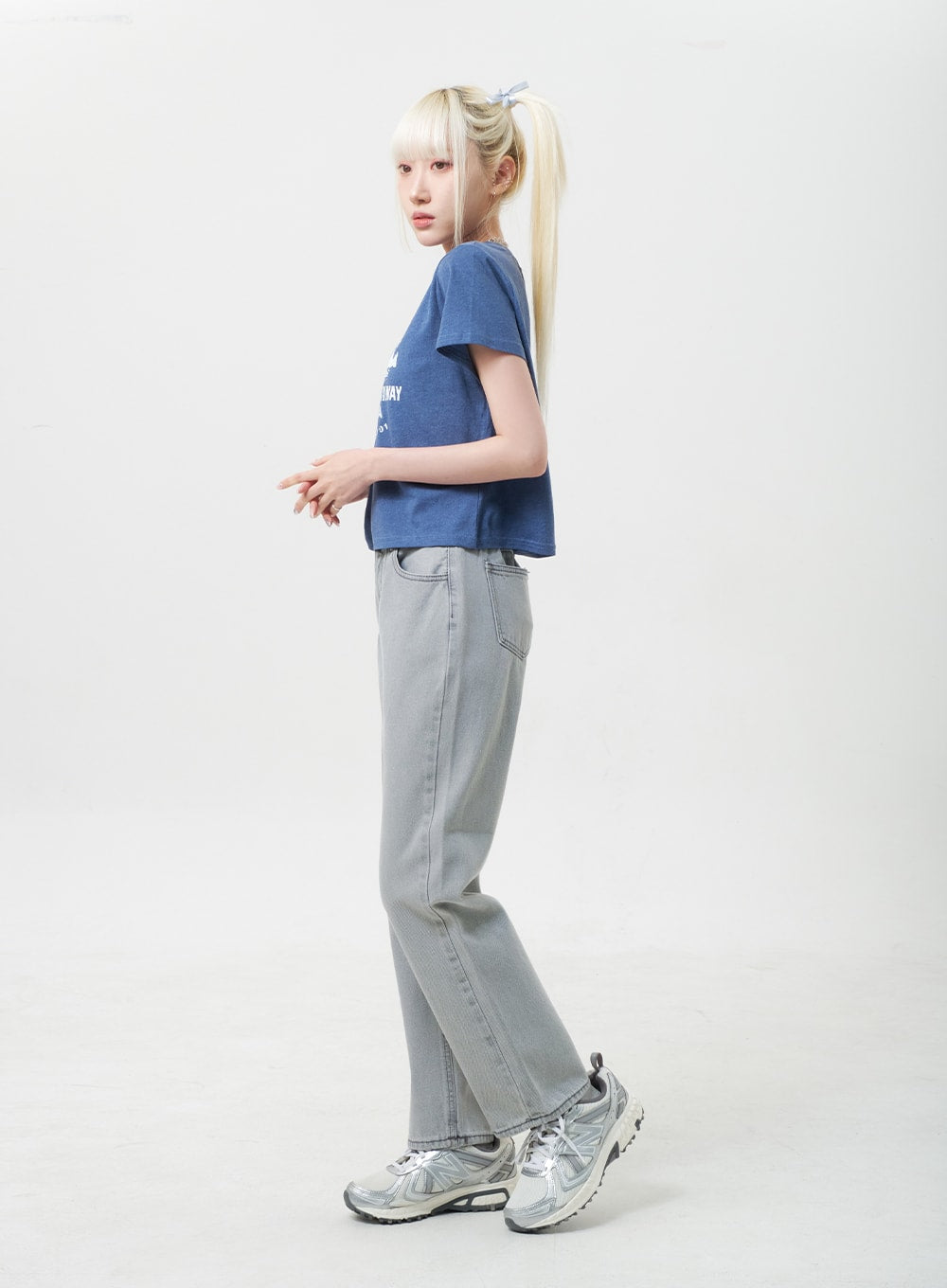 Straight Leg Jeans BU302 in gray, side view on model walking, wide-fit straight leg silhouette with banded waistband, paired with blue crop tee and chunky sneakers.