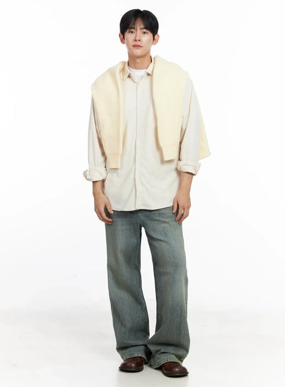 Men's Blue Washed Semi-Flared Jeans IJ521 in blue, full-body front shot on model, relaxed wide-leg silhouette with washed finish, styled with cream shirt and ribbed knit draped over shoulders.