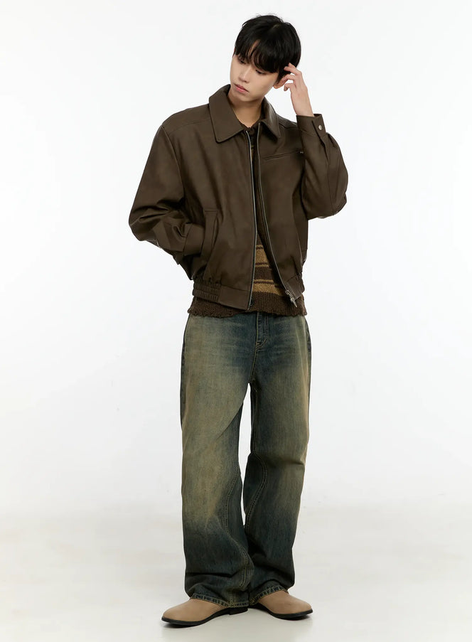 Men's Textured Faux Leather Jacket IN503 in brown, full-body side-angled shot on model with hand raised, relaxed faux leather bomber silhouette, ribbed hem, styled with wide-leg vintage jeans and tan loafers.