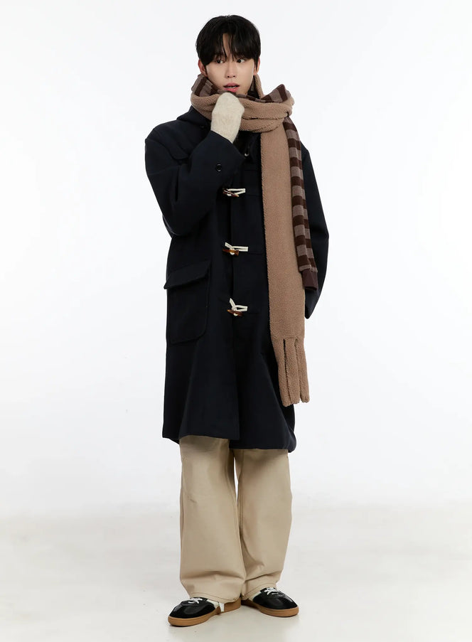 Soft Plush Winter Scarf ID502 in brown stripe, full-body front on male model, wrapped high at neck, paired with navy duffle coat and beige wide-leg trousers.