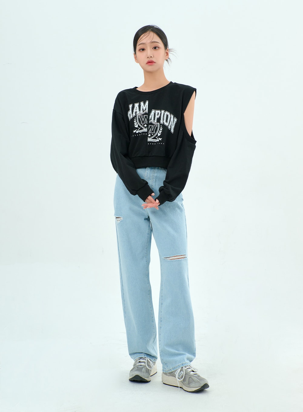 Ripped Basic Jeans BA328 in light blue, full-body front shot on model, casual wide-fit destroyed denim with knee rips, styled with black graphic crop sweatshirt and sneakers.