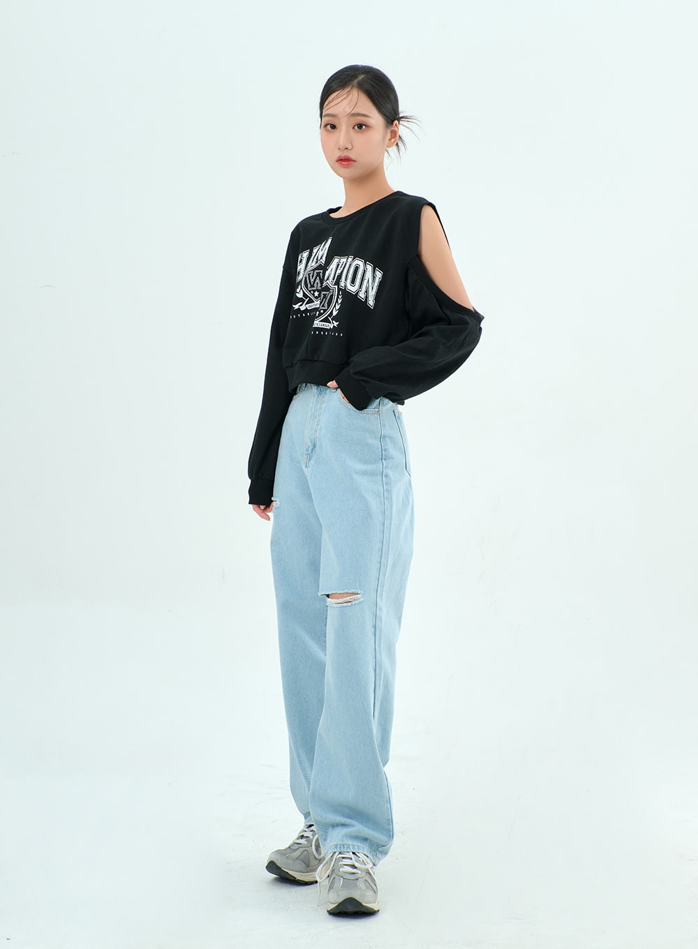 Ripped Basic Jeans BA328 in light blue, three-quarter front angle on model, wide-leg destroyed denim with knee slit, paired with black cold-shoulder graphic sweatshirt and sneakers.