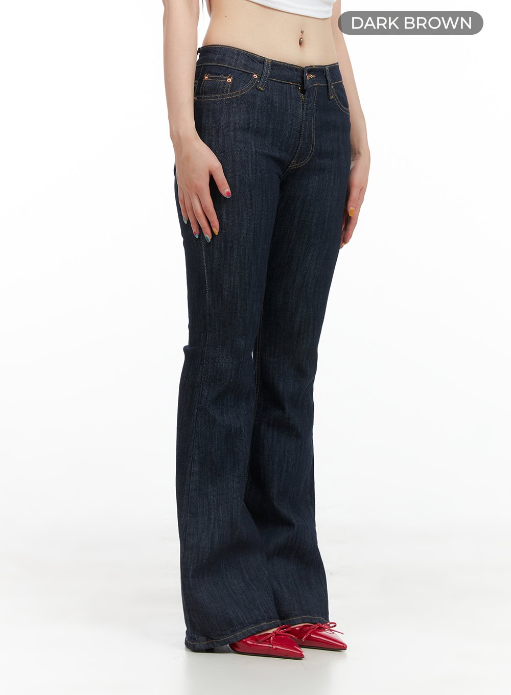 Lila Slim Fit Bootcut Jeans CG409 in dark brown, angled front side view on model, slim-fit bootcut denim with low-rise waist and five-pocket styling, paired with red bow heels.
