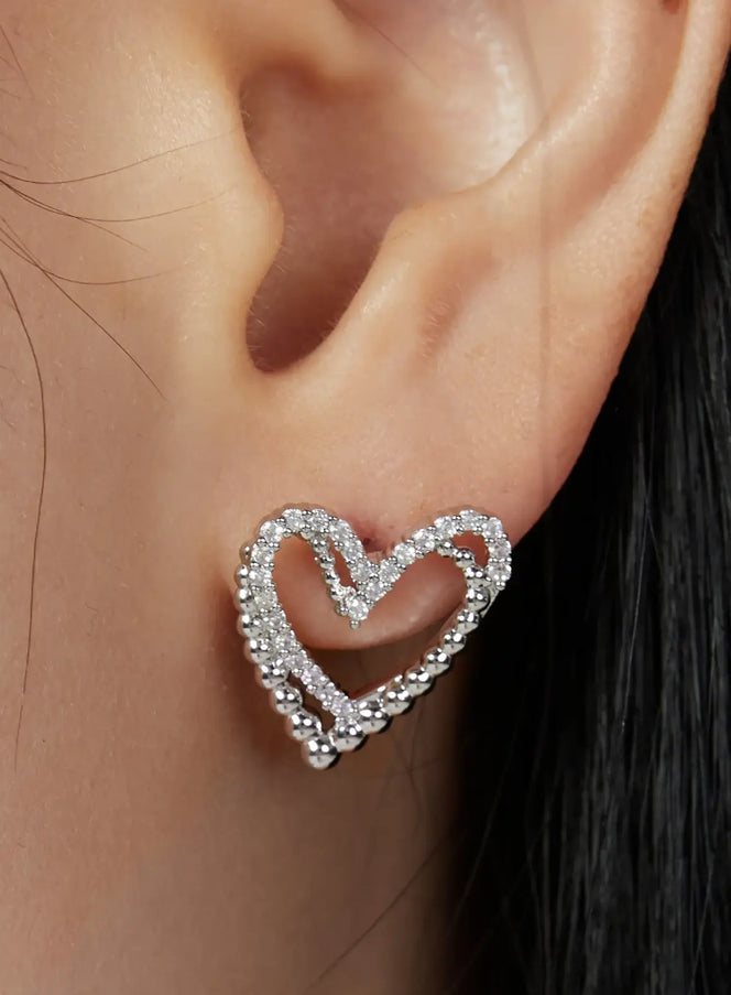 LEWKIN Julian Earring IU503 in silver, extreme close-up worn on model's ear, open heart silhouette with crystal-set inner edge and beaded outer border stud.