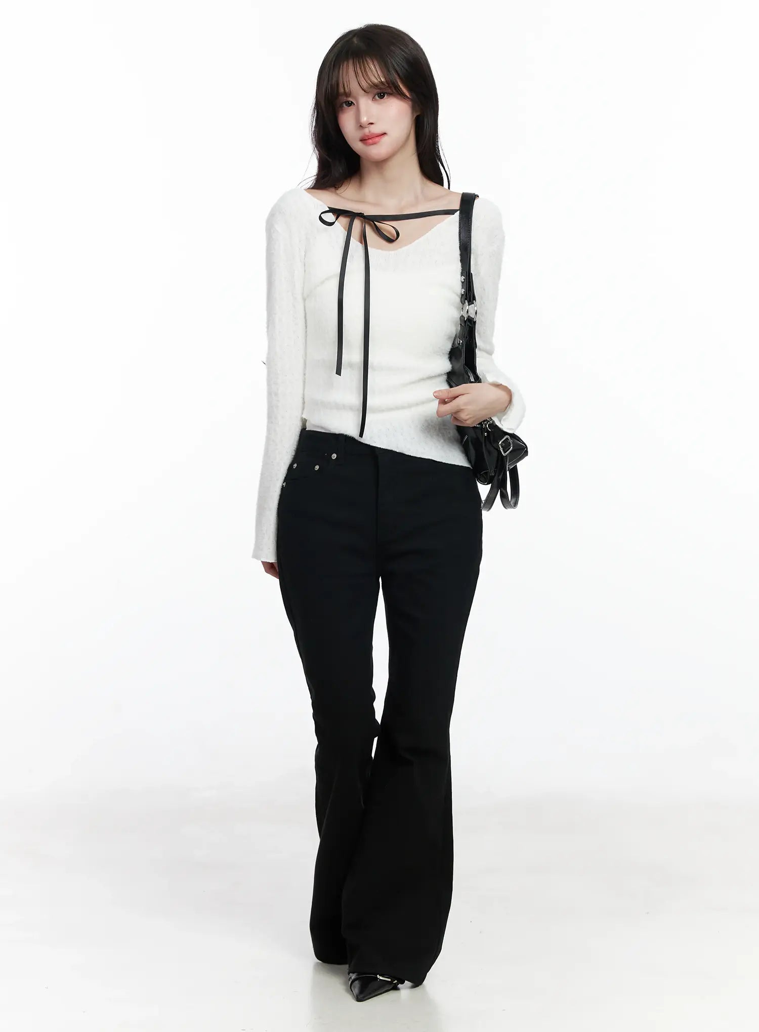 Ellis High-Waist Bootcut Jeans IJ529 in black, full-body front editorial shot on model carrying black mini bag, high-waist bootcut jeans styled with white ribbon-neck knit, casual feminine look.