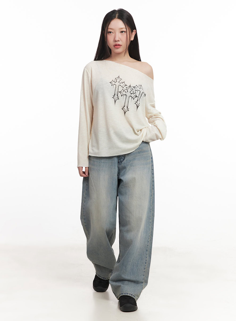 Casey Washed Baggy Jeans IM528 in light blue, front full-length on model walking, wide baggy washed denim with faded sun-bleached finish, hem pooling at floor, styled with cream graphic knit top.