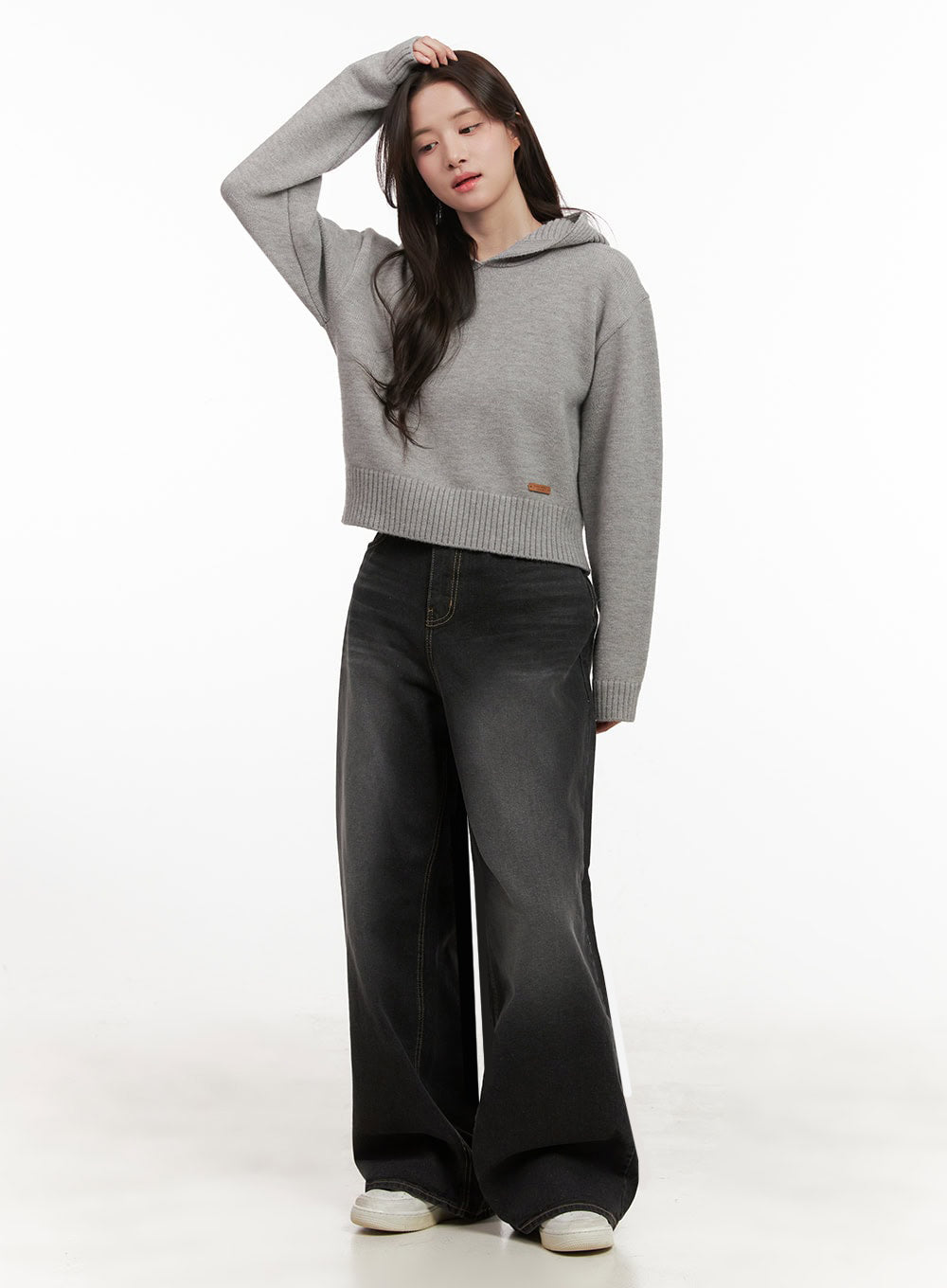 Christina Washed Baggy Jeans IJ510 in black, full-body front shot on model with dynamic pose, high-rise wide-fit washed denim styled with cropped grey hoodie and white sneakers.