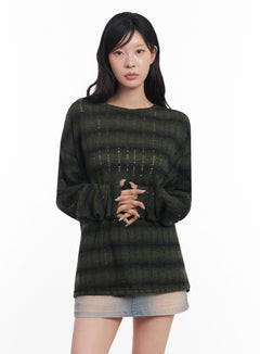 LEWKIN Striped Knit Long-Sleeve Pullover IC503 in dark green, front view on model, loose-fit round neck with semi-sheer distressed stripe texture, paired with light wash denim mini skirt.