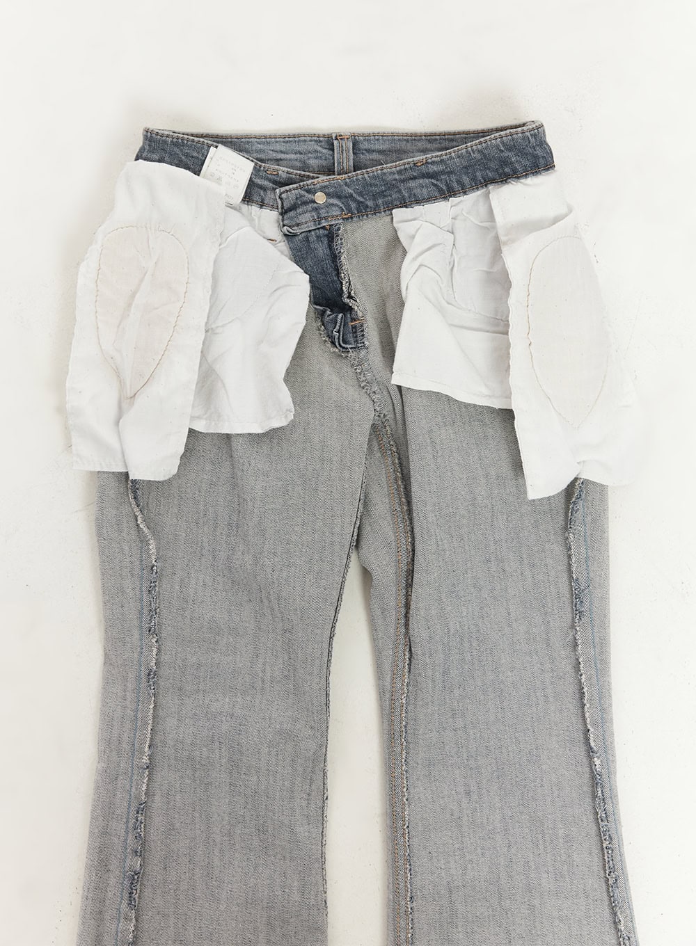 Rachel Washed Bootcut Jeans with Hip Pads CF518 in gray, flat detail shot showing removable hip pad inserts pulled out of waistband pockets, revealing inner construction and bootcut leg.