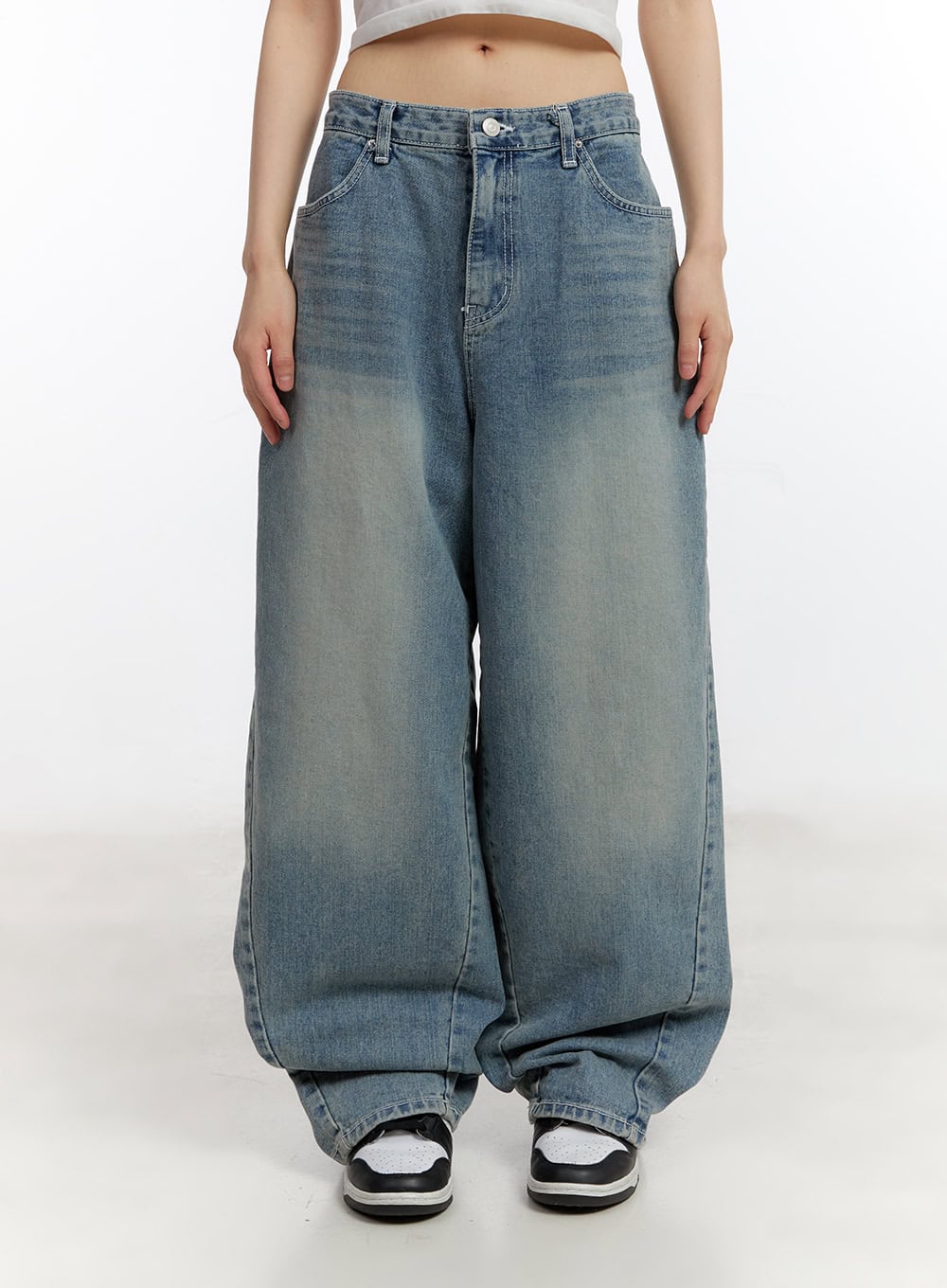 Jillie Washed Baggy Jeans CA508 in blue, front waist-to-hem view on model, low-rise washed denim with wide baggy silhouette, button fly closure, and floor-grazing hem over sneakers.