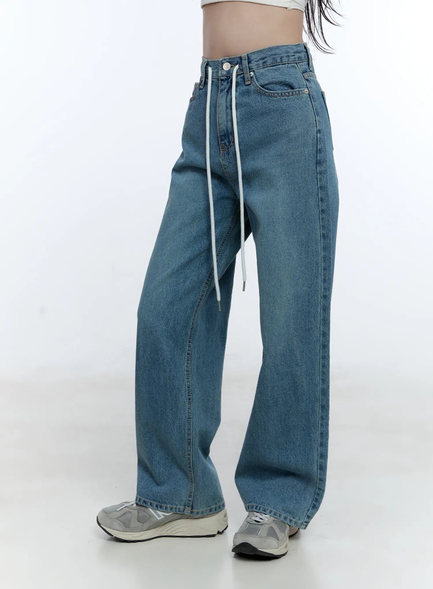 High-Waist Wide-Leg Drawstring Jeans CG513 in blue, angled front close-up on model, emphasizing high waist, white drawstring tie, front pockets, and relaxed wide-leg washed cotton silhouette.
