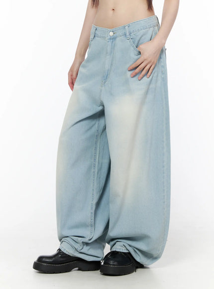 Ozzy Washed Wide Leg Jeans CU519 in light blue, angled front close-up on model, hand in pocket, low-rise waistband and dramatic volume of bleached wide leg.