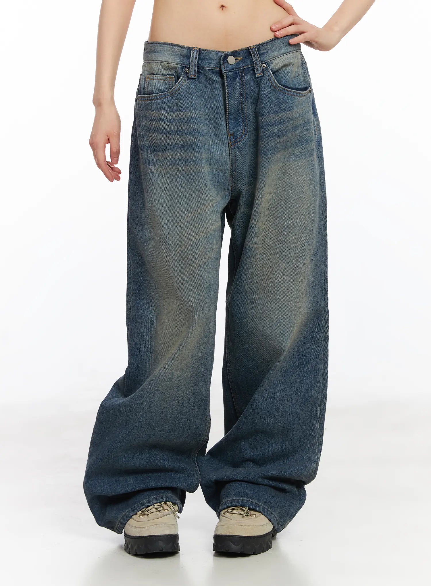 Miriam Wide Leg Jeans CD519 in blue, front mid-shot on model, emphasizing wide-fit volume and yellow-toned washed fading from waist to hem, stacked over chunky sneakers.