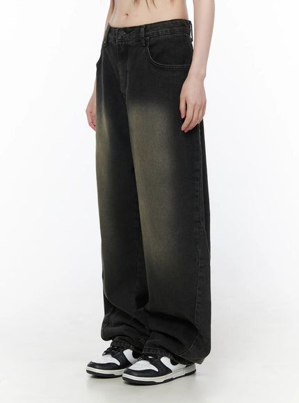 Bodie Vintage Wash Wide Leg Jeans CU519 in black, side full-length on model, arms relaxed, oversized balloon wide leg silhouette with vintage khaki fade, hem stacking over sneakers.
