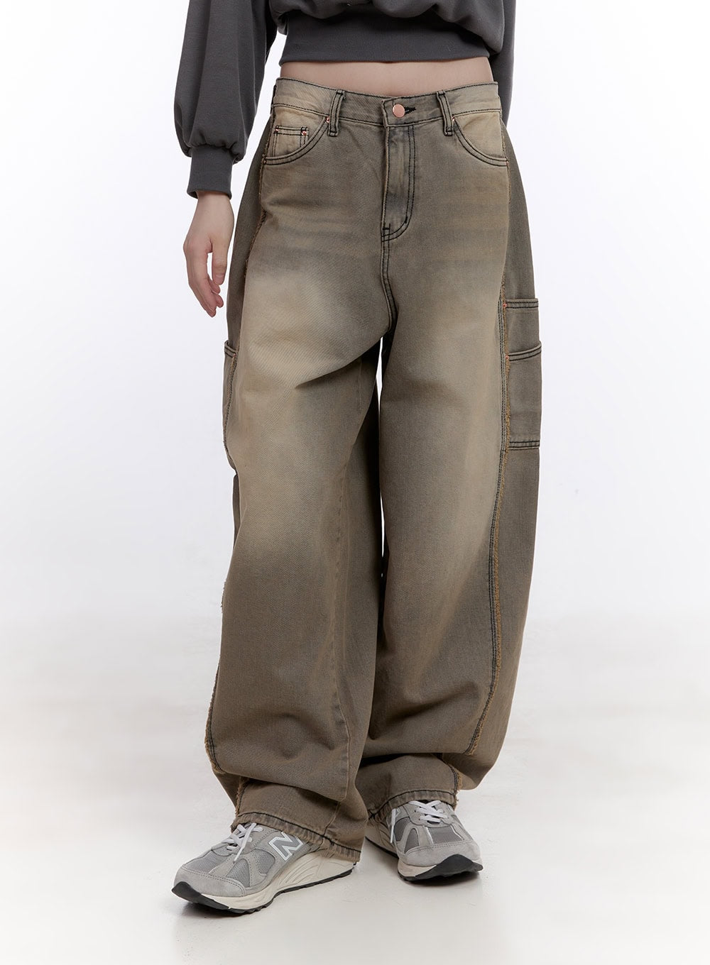 Sara Stitched Pocket Baggy Jeans CF512 in Beige, front three-quarter close-up on model, washed denim with stitched side pockets and wide baggy silhouette, paired with sneakers.