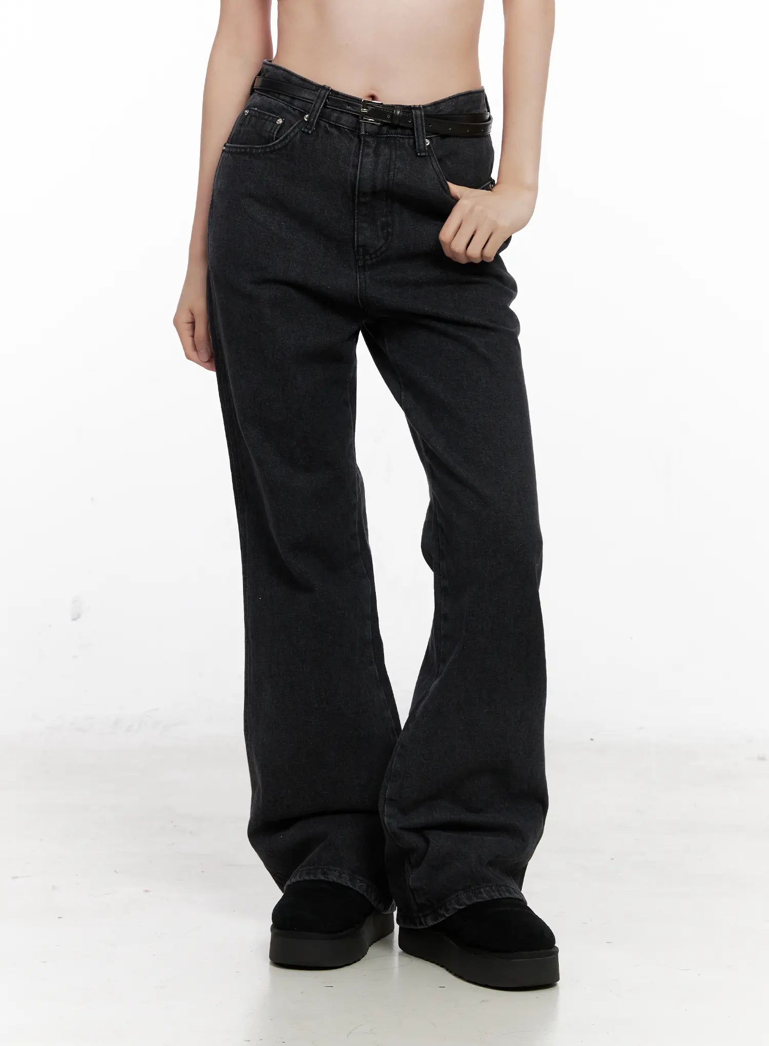Eileen Belted Flare Jeans CN504 in washed black, front lower-body close-up on model, highlighting flare hem, washed denim texture, asymmetric belt, and five-pocket construction.