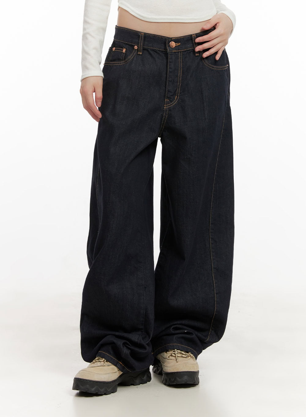 Fernanda Balloon-Fit Baggy Jeans CJ502 in dark blue, front mid-shot on model, low-waist wide-fit denim highlighting contrast topstitching, copper-tone button, and ballooned leg hem pooling over chunky sneakers.