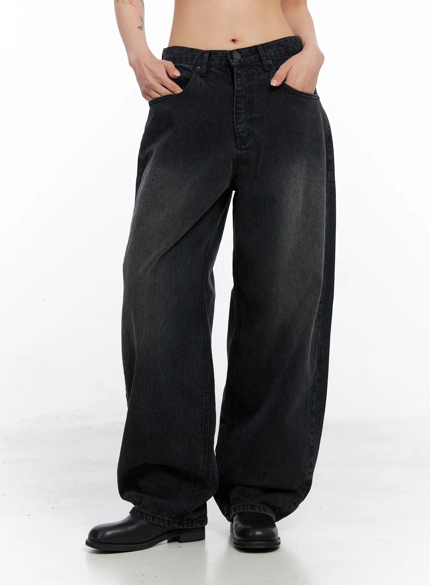 Ivey Washed Baggy Jeans CC1809 in black, front three-quarter view on model with hands in pockets, wide baggy cotton denim, low-rise waist, washed fading across thighs.
