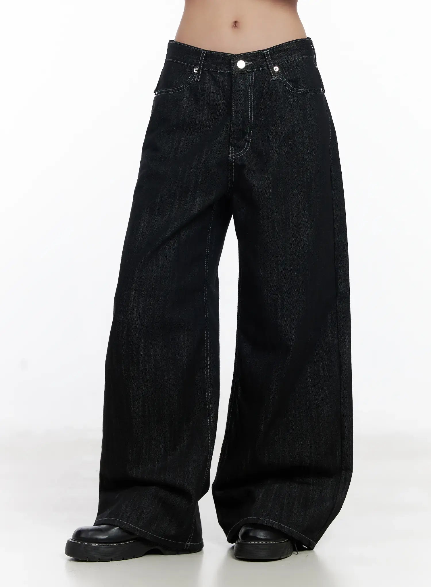 Violet Studded Baggy Jeans CJ530 in black, front mid-shot on model, low-rise waistband with silver rivets and button, baggy wide-leg cotton denim with contrast stitching, hem grazing black loafers.