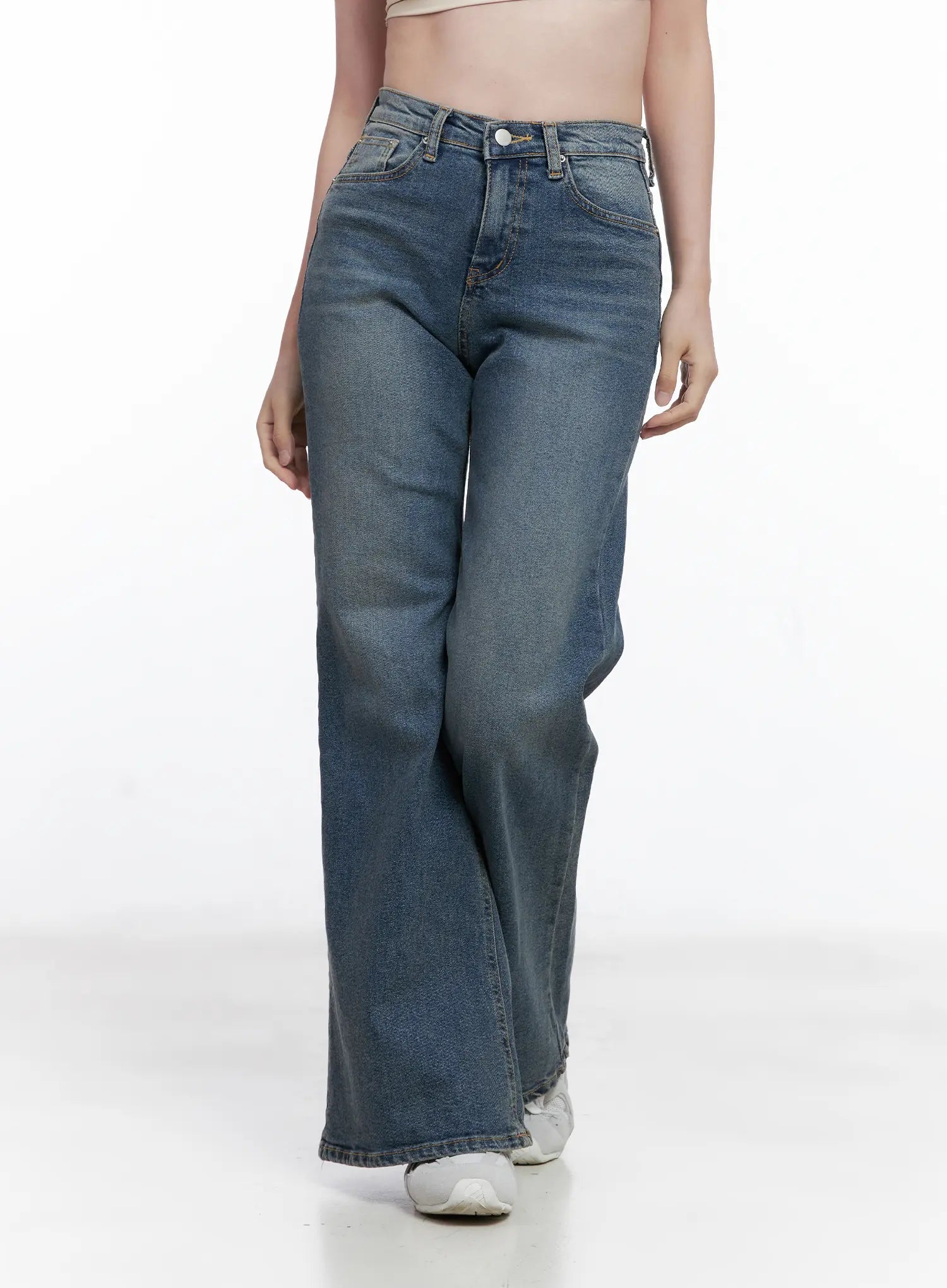 Juae High Waist Flare Jeans CG520 in blue, front three-quarter view on model, relaxed high-waist fit, subtle washed fade, long flare hem, white sneakers.