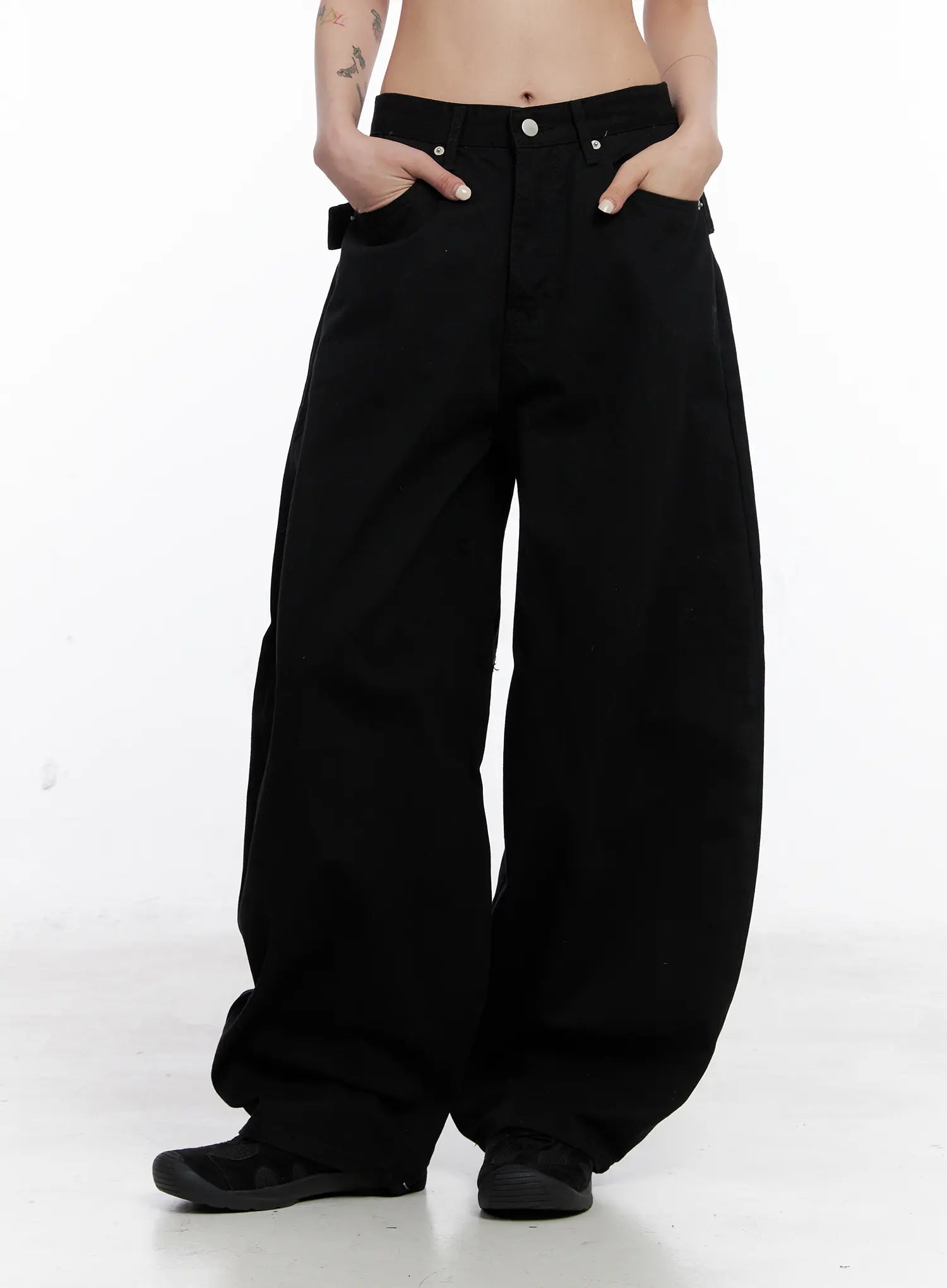 Nana Studded Belt Balloon Jeans CS512 in black, front waist-to-hem close-up on model, hands in pockets, low-rise button fly, balloon leg volume and cotton twill texture visible.