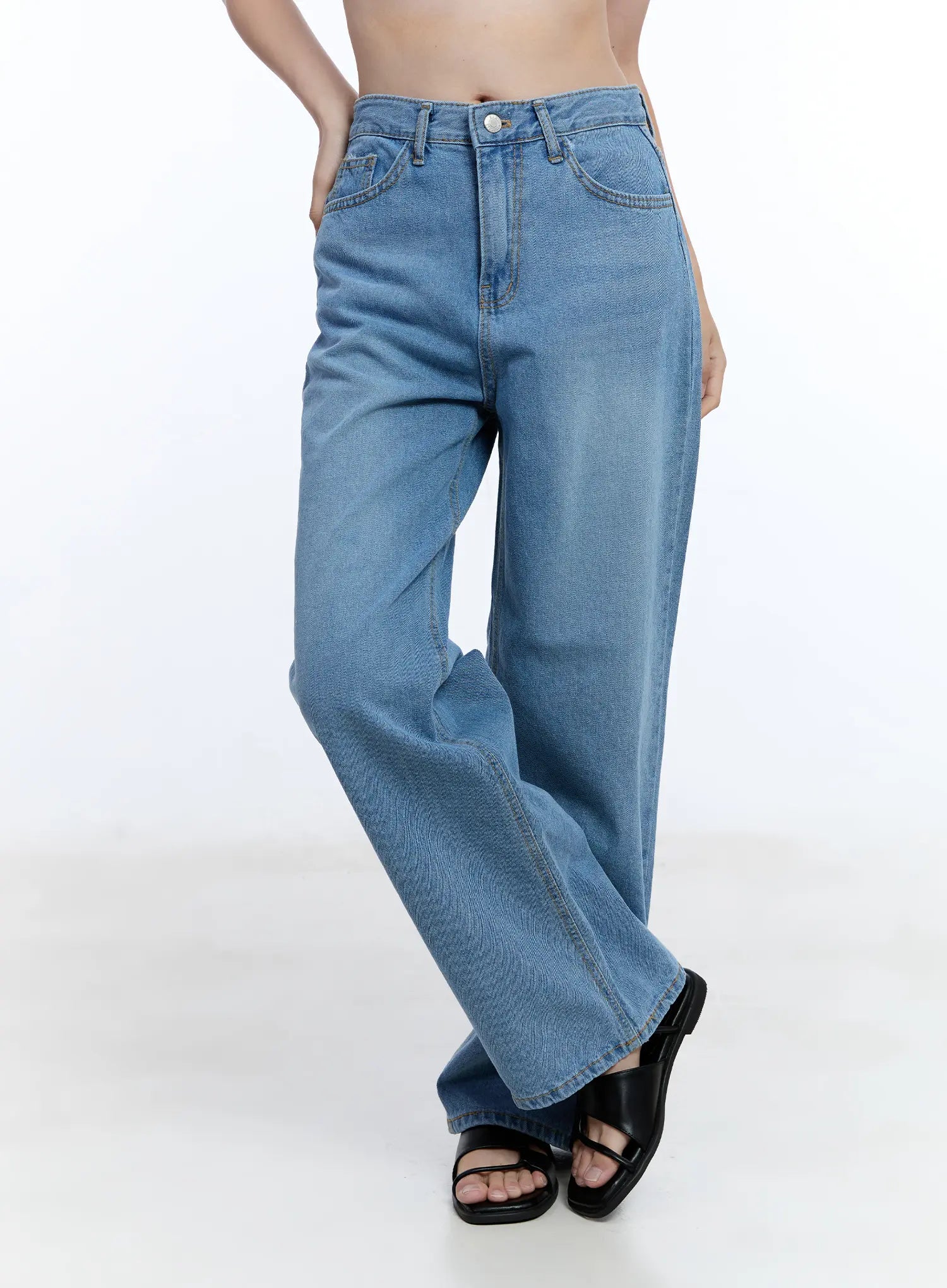 Jisoo Straight-Fit Jeans CU513 in blue, front angled waist-down shot on model, wide-fit washed cotton denim with button closure and 5-pocket detail, black sandals.