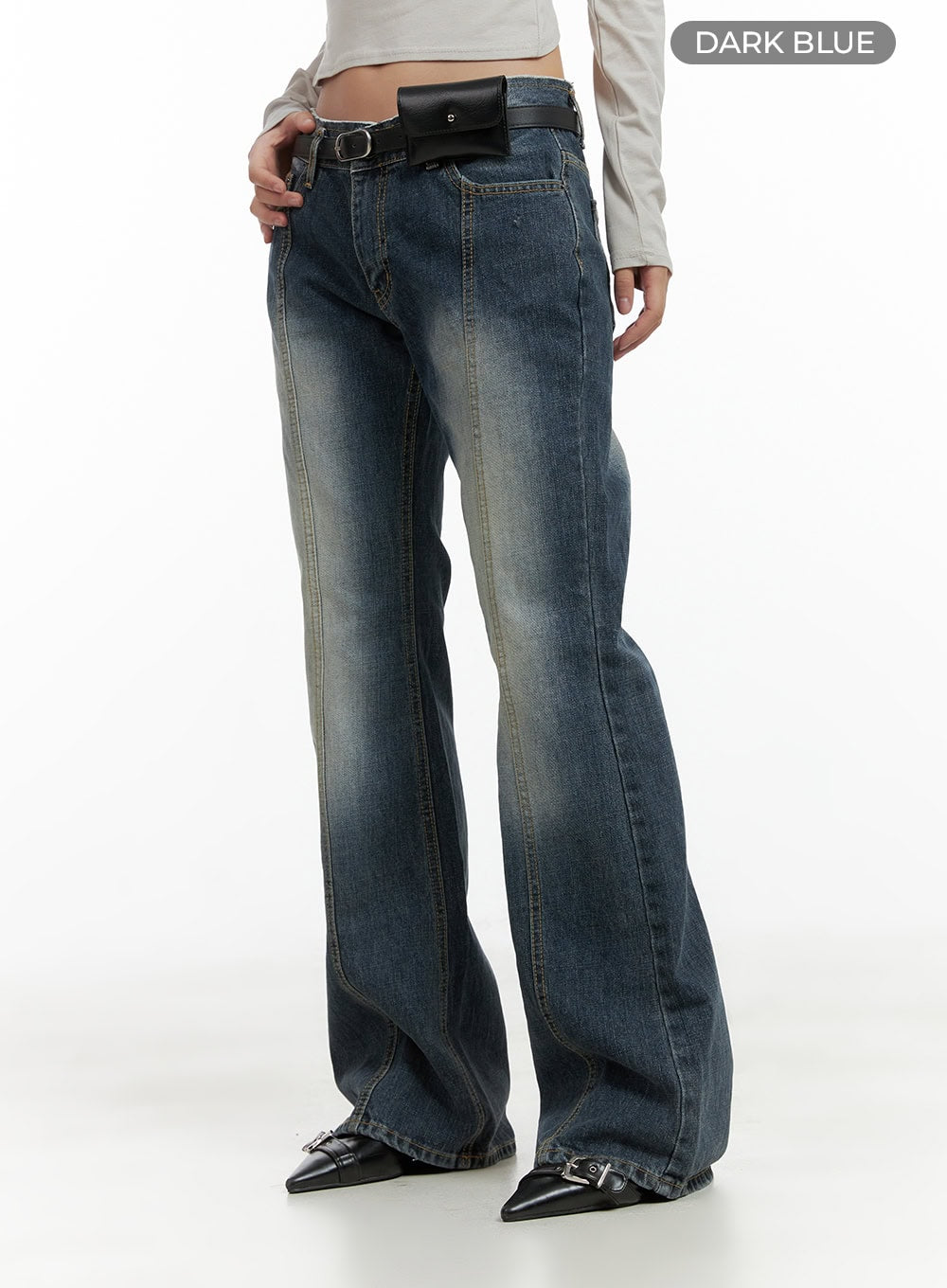Low Rise Front Seam Bootcut Jeans CL417 in dark blue, three-quarter front-side shot on model, washed denim with front seam and slim bootcut leg, styled with black belt bag and buckle shoes.