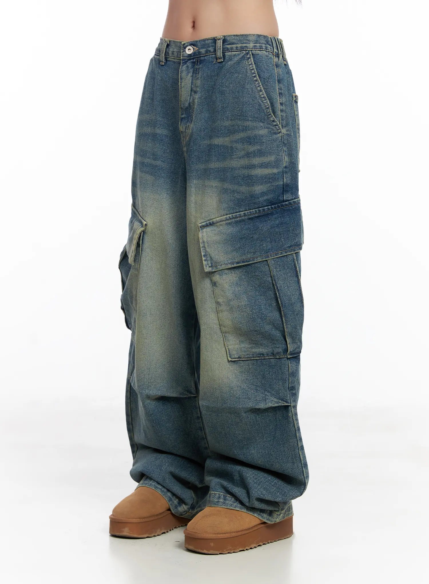 Jake Wide-Leg Cargo Jeans CJ515 in blue, side-angle shot on model, emphasizing layered flap cargo pockets, vintage washed fade, and voluminous wide-leg cotton denim drape over tan platform boots.
